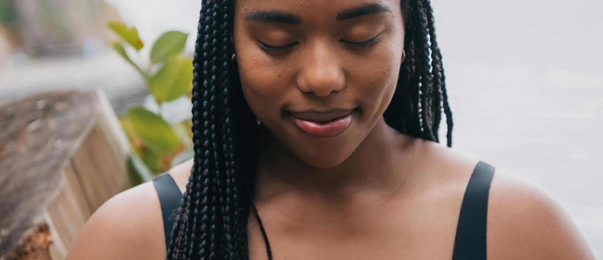 African American woman meditating outdoors with closed eyes, embracing serenity by the sea.