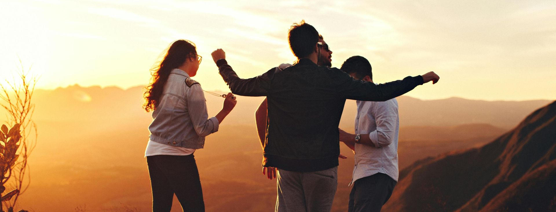 Joyful group of young adults enjoying a sunset view in a mountainous landscape in Brazil.